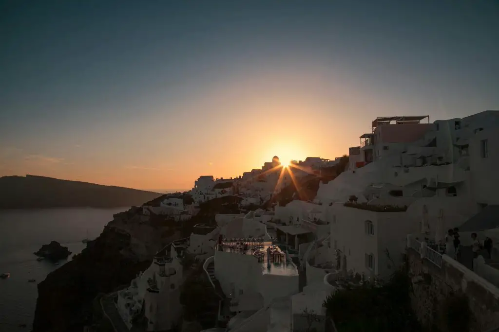 Breathtaking sunset view of the iconic white architecture on Santorini's cliffs, Greece.