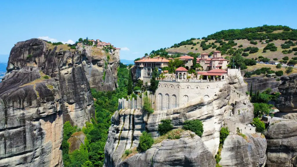 Stunning aerial landscape of the Meteora monasteries perched atop dramatic cliffs in Kalampaka, Greece.